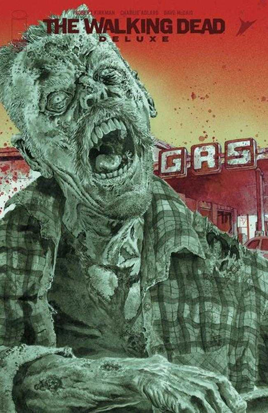 Comic book cover of "The Walking Dead Deluxe," featuring a zombie in a plaid shirt in front of a gas station.