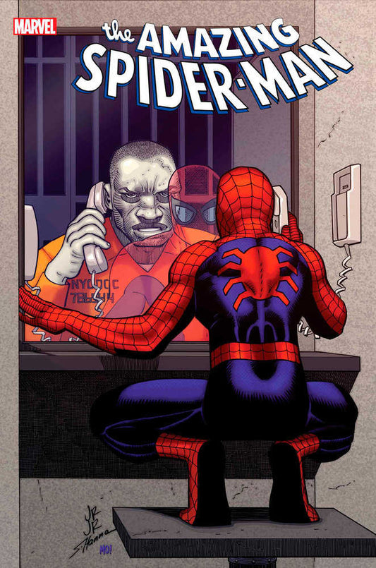 Comic book cover featuring Spider-Man talking on the phone with a bald, scarred prisoner in an orange jumpsuit.