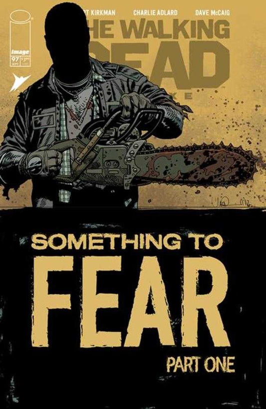 Comic book cover: The Walking Dead #97, “Something to Fear Part One,” silhouetted figure with chainsaw, title in large gold lettering.