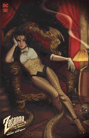 Comic book cover featuring Zatanna reclining in an ornate chair. She wears a tuxedo-style outfit with fishnet stockings. Behind her are red curtains and a shadowy figure, with a lamp and skull visible to her right.