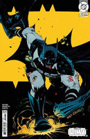 Comic book cover featuring Batman in a dynamic pose with a yellow background, blood on his face and body, wearing a spiked shoulder pad and cape.