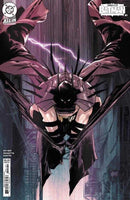 Comic book cover featuring Batman in a unique suit with spikes, set against a backdrop of lightning and urban architecture.