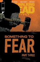 Comic book cover featuring a man holding a hammer. The text reads "The Walking Dead Deluxe" and "Something to Fear Part Three".