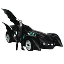 Black Batmobile toy with a gray-haired man in a black suit standing next to it.