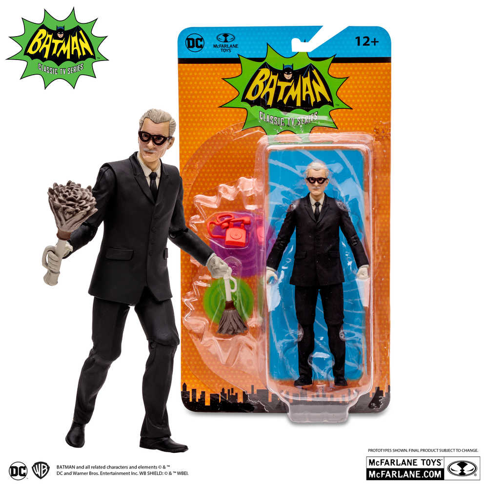 A Professor Strange action figure standing next to a sealed action figure. Both figures wear black suits and spectacles. One is holding a weapon, the packaging is bright orange and green.