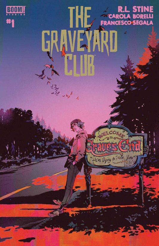 Comic book cover with a boy leaning against a welcome sign. The title is "The Graveyard Club". The sign reads "Welcome to Graves End, We're Dying to Have You". The background is a colorful landscape with trees and birds.