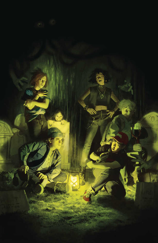 A group of teens lit by a lantern in a cemetery.