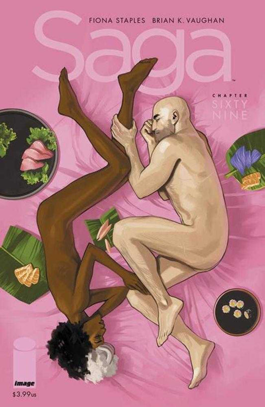 Comic book cover depicting two nude people lying on a pink sheet surrounded by plates of food. One person is pale and bald, the other is dark skinned with curly hair. The title "Saga" is in large pink letters at the top.