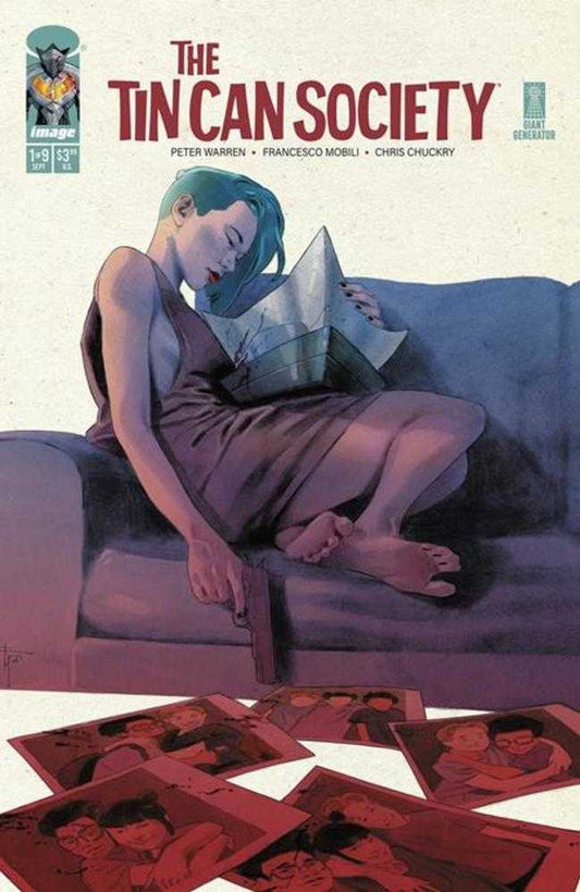 A woman sitting on a couch, wearing a dress, reading a book and holding a gun, with photos scattered on the floor.